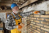 mason completing brick repair on wall